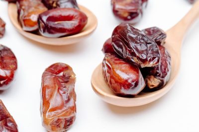 side-view-wooden-spoons-with-dried-dates-white-background_141793-8754